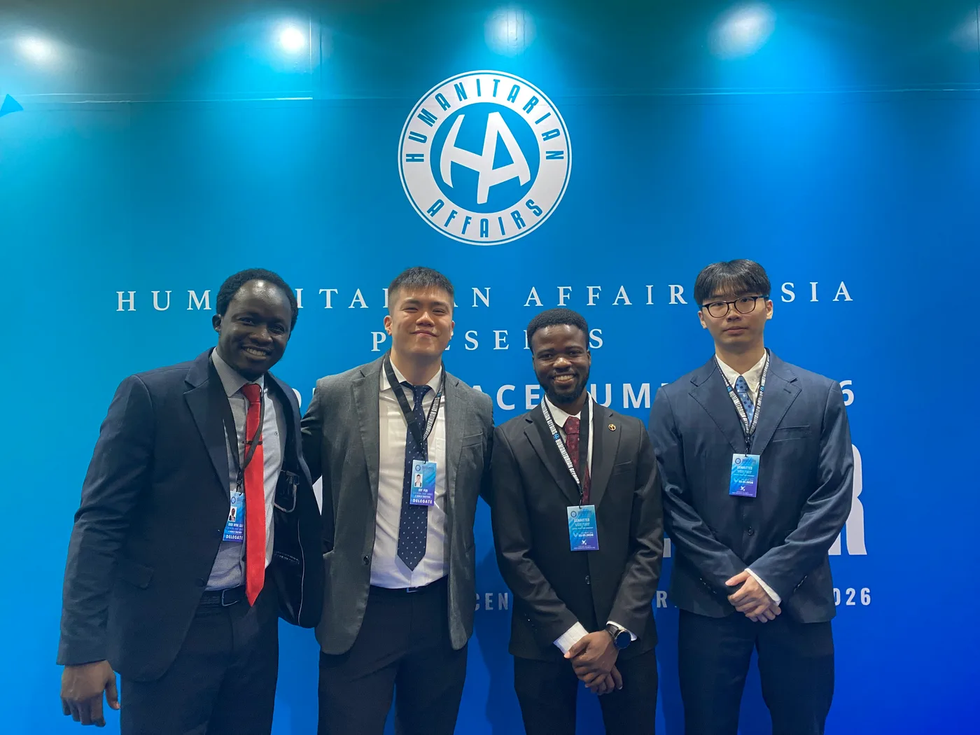 Roy 與其他代表在第五屆 Global Peace Summit 背板前合照